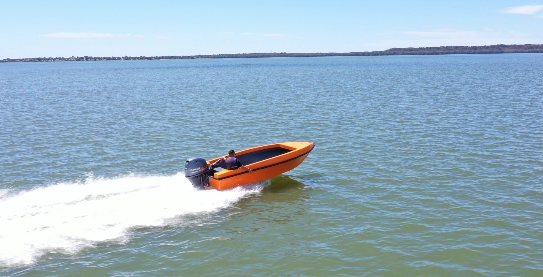 Orange Mighty Boy skimming across the lake